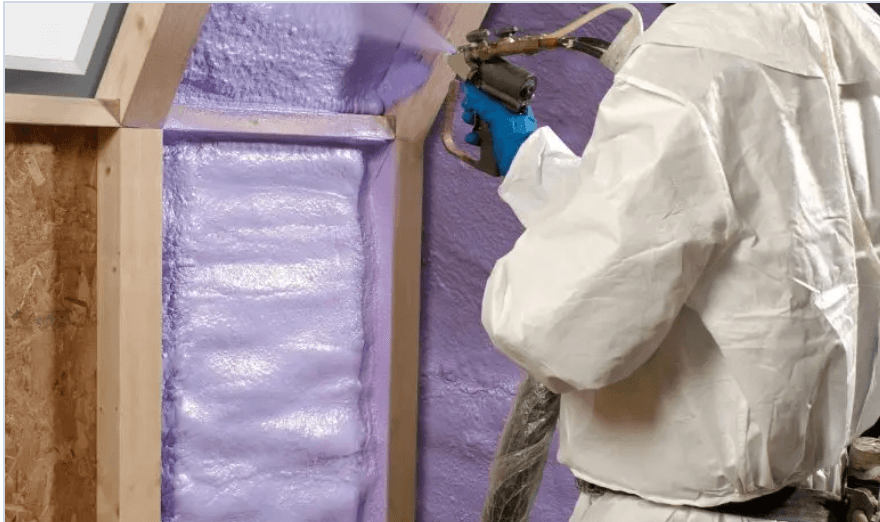 Purple closed-cell spray foam being applied along a roofline