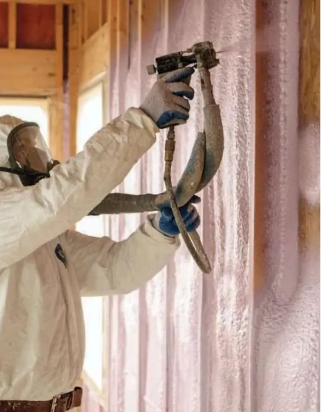 Installer spraying closed-cell spray foam insulation into wall framing in Vancouver